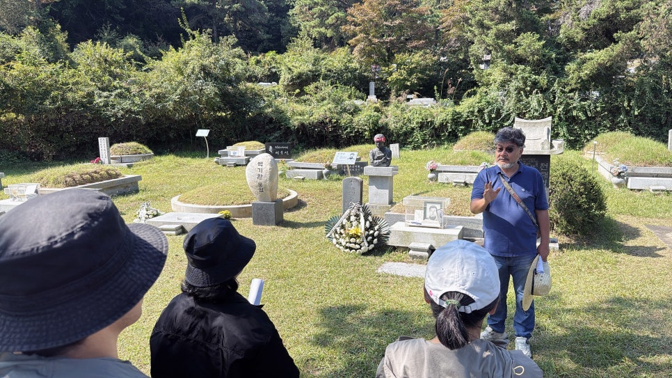 역사를 바꾼 것은 초인이 아니었습니다 — 백기완·이소선·전태일 묘역이 한자리에 모인 구역에서 해설을 듣는 참가자들